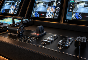 Custom yacht glass helm electronics console with dual displays navigating at twilight